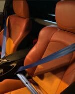 حزام أمان أزرق فاخر بتصميم عصري يبرز على مقاعد سيارة جلدية بنية مثقبة، إكسسوارات auto premium من Roh Accessoires بالمغرب.